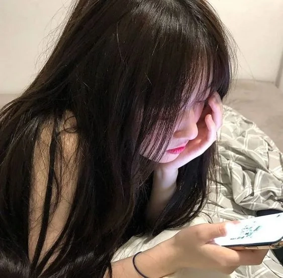 Cô gái xinh che mặt bằng điện thoại đầy phong cách.
